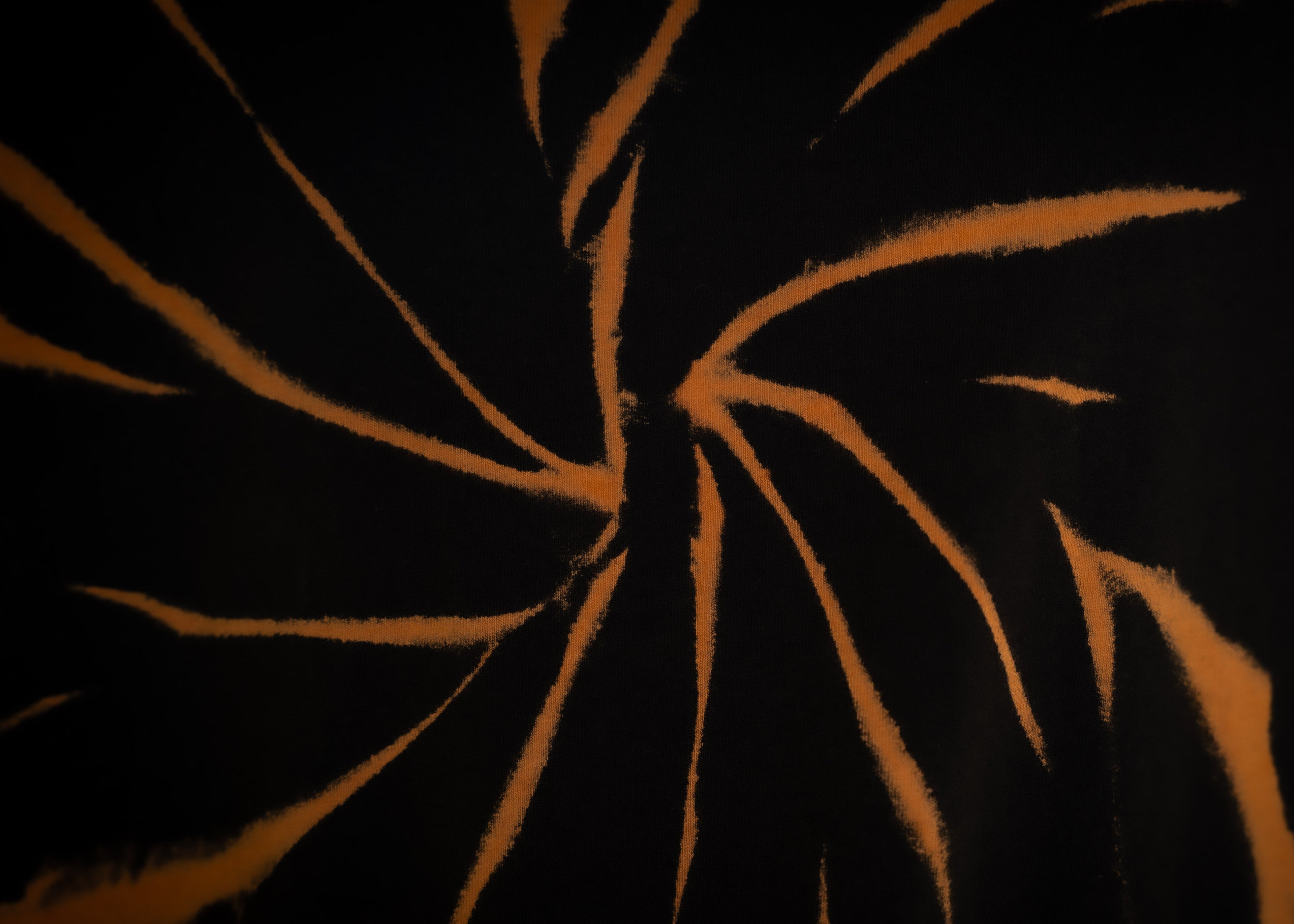 Close-up of a textured surface with orange patterns on a black background